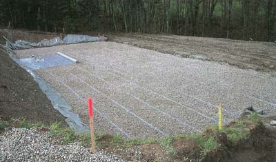 Station d'assainissement rustique de type fosse septique toutes eaux, filtre pouzzolane, filtre à sable vertical drainé étanche et rejet dans une zone naturelle de dissipation.